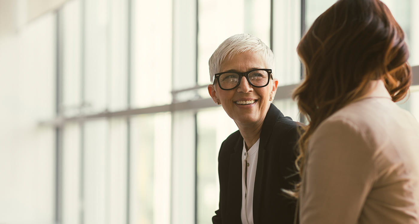 a woman smiling at another woman facing her